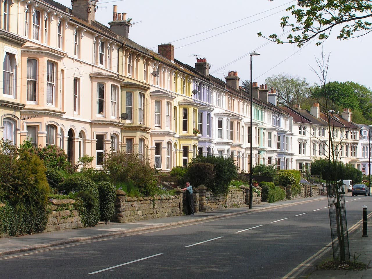 Row of ordinary British terraced homes with pitched roofs and front gardens