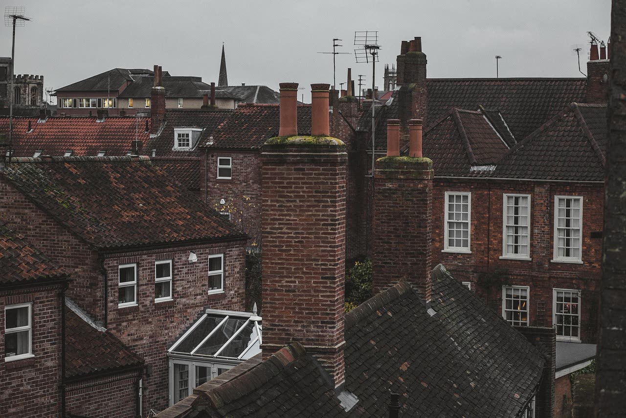 English residential roofline with brick walls, tiled roofs and chimneys